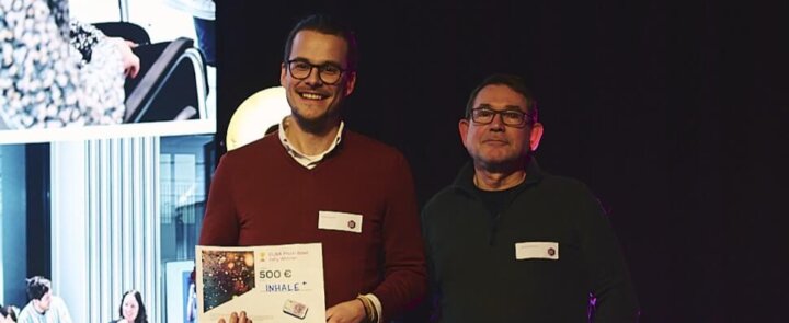 Two people on stage at ELSA Pitch Bowl 2023 - winner inhale+ receives award certificate worth €500.