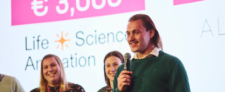 Three people on stage at ELSA Pitch Bowl 2024 - winner Avocet Bio GmbH receives award certificate worth €500.